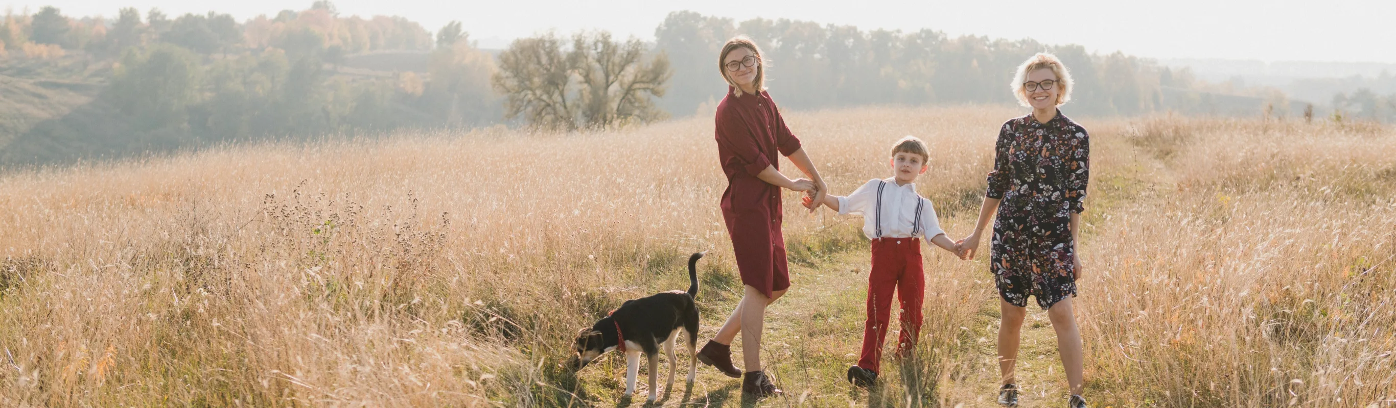 family in field and dog